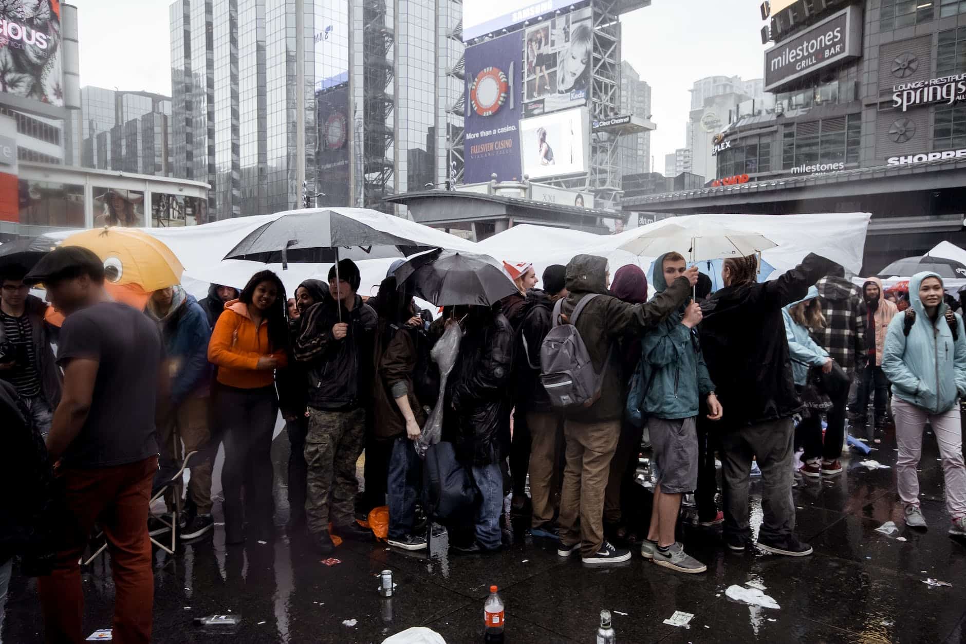 crowd of people standing under umbrellas